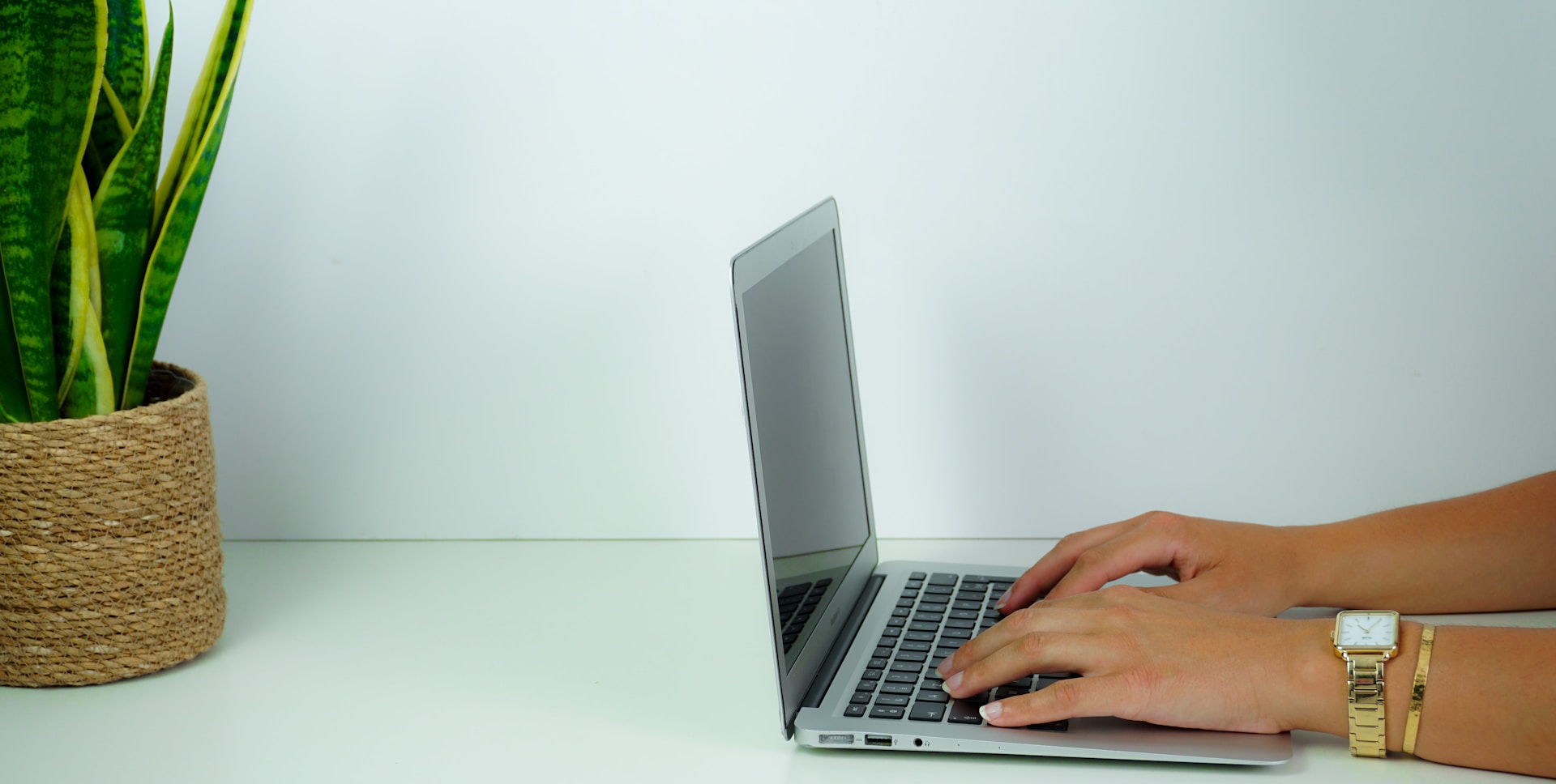 person using macbook pro on white table