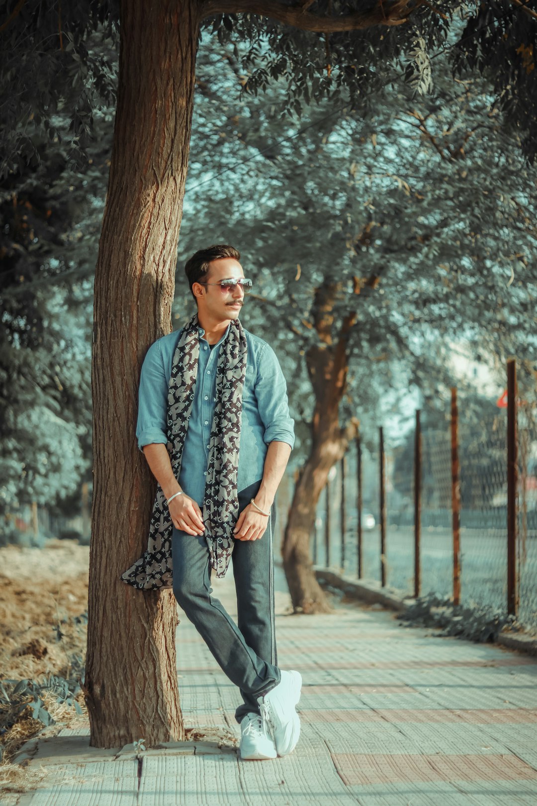 man in black and white floral button up shirt standing on sidewalk during daytime