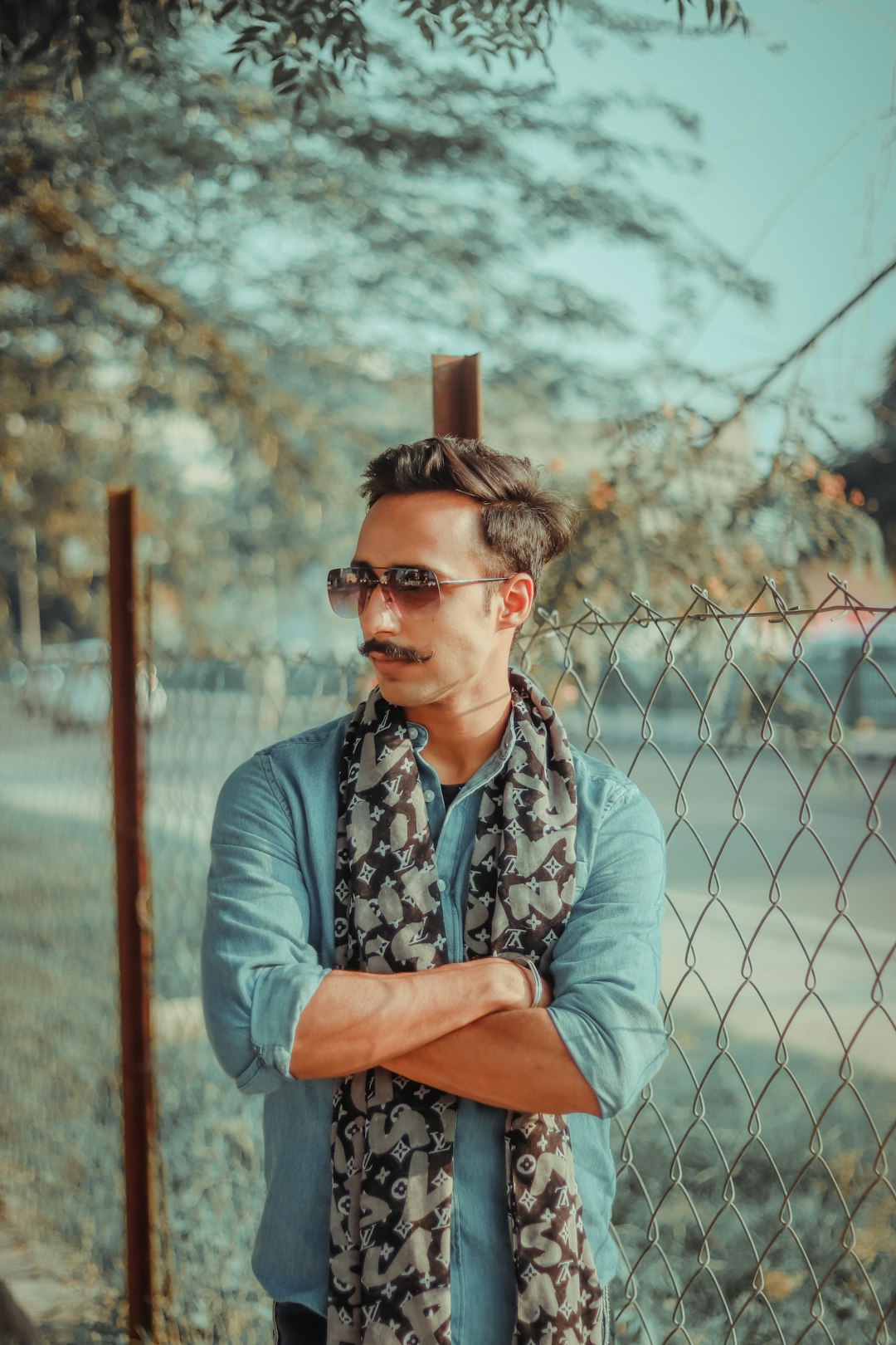 man in blue and white floral button up shirt sitting on brown wooden chair