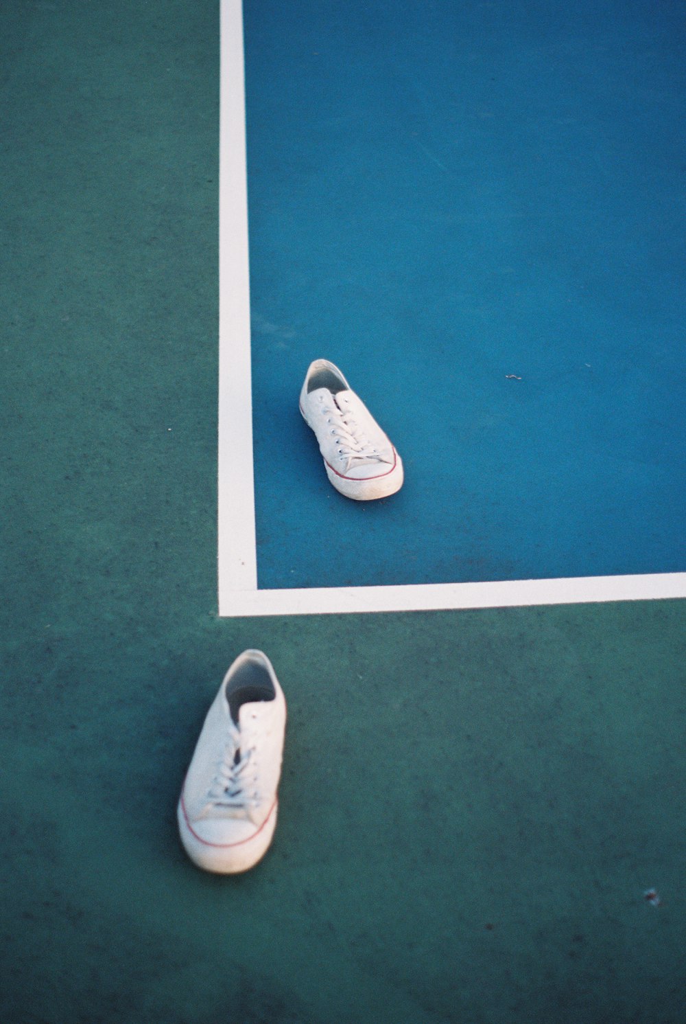white low top sneakers on green floor