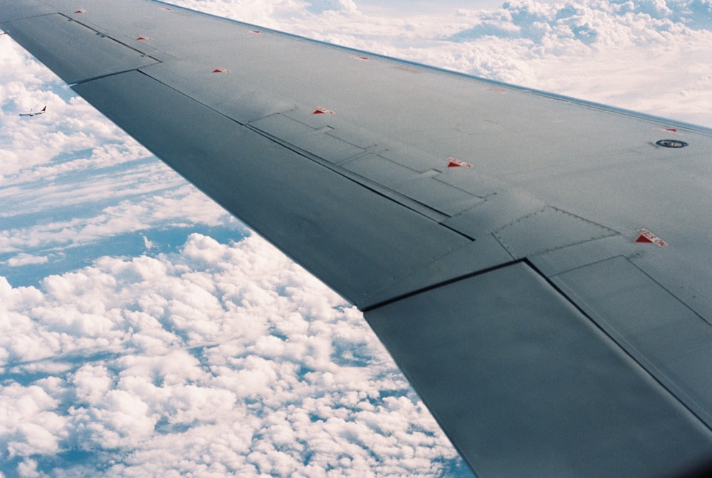 airplane wing over white clouds during daytime