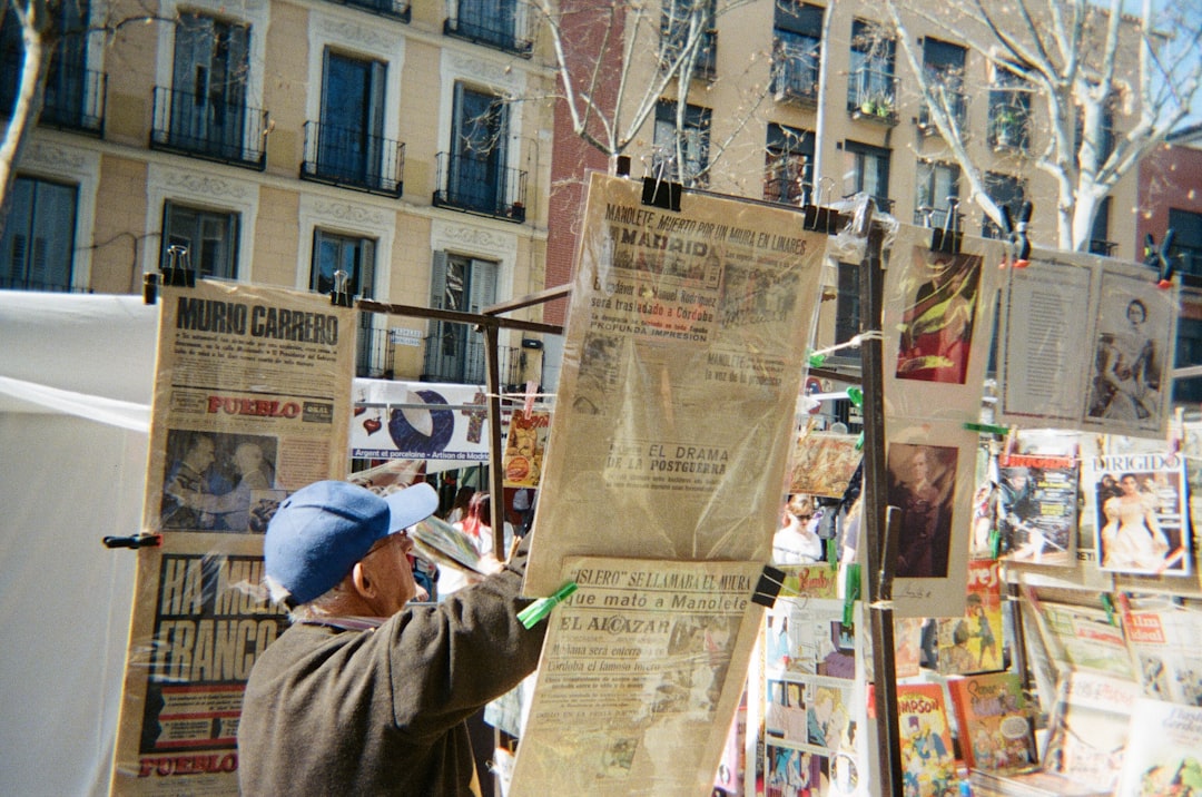 man in brown jacket holding green stick