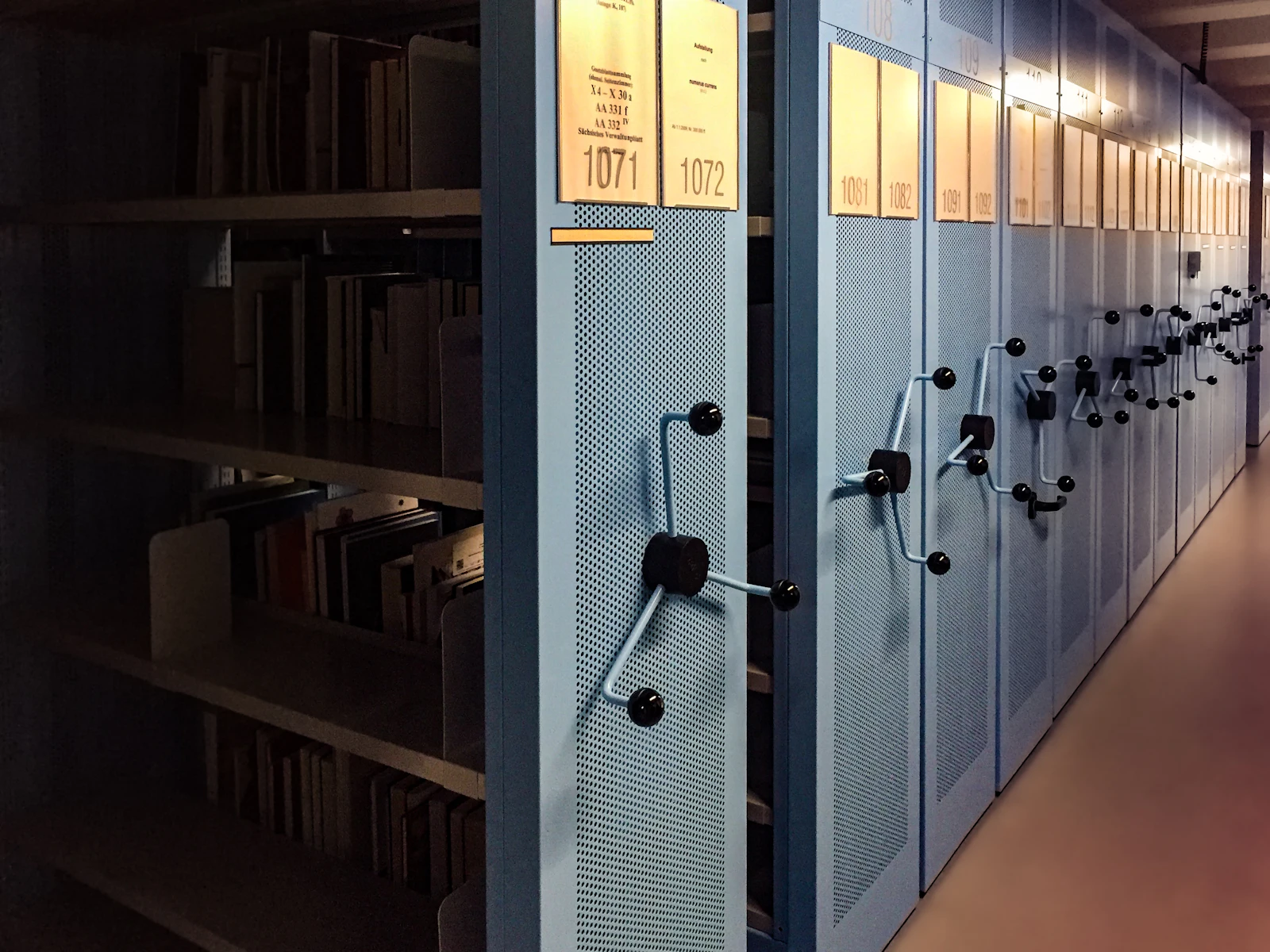 Rows of grey archive shelves in a state archive.