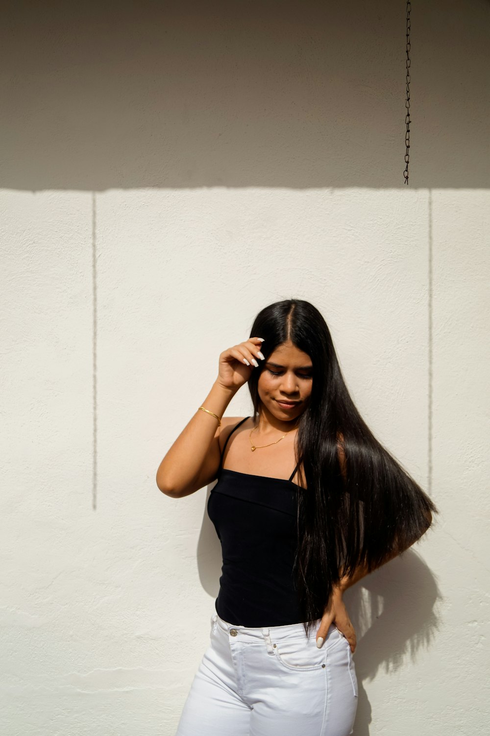 woman in black tank top covering her face with her hair