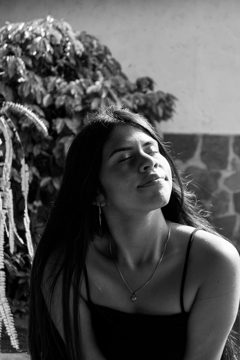 grayscale photo of woman in spaghetti strap top