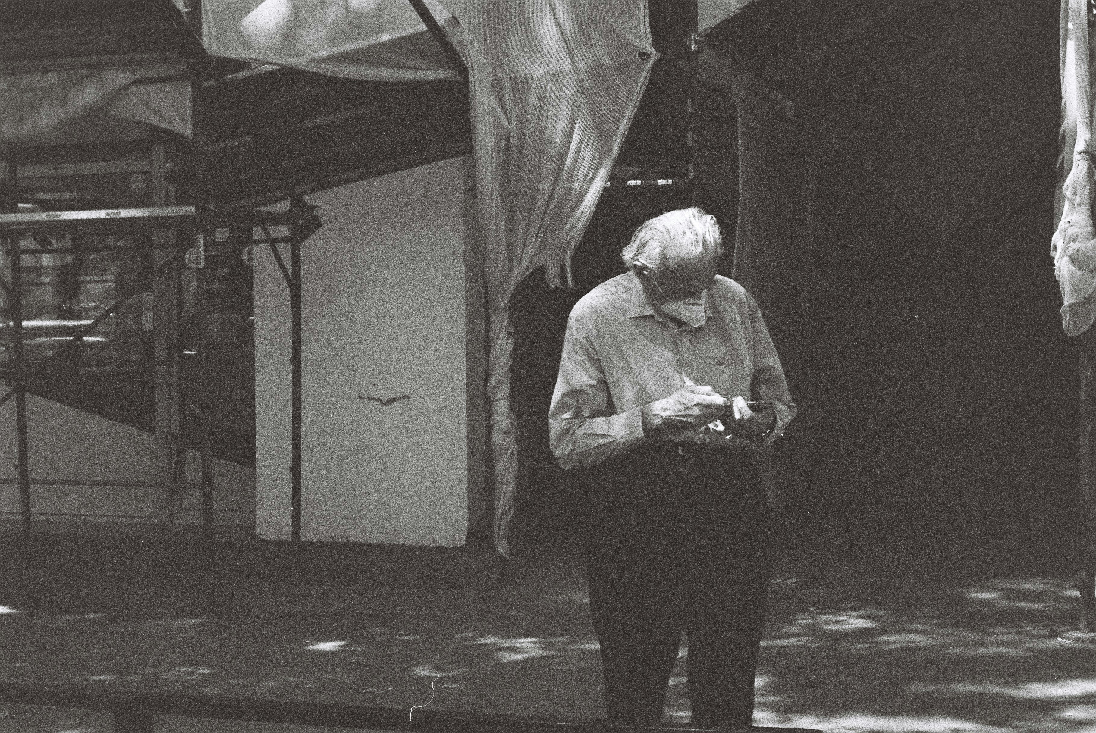 man in white dress shirt and black pants standing on street