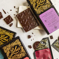 A variety of cannabis chocolate bars displayed with vibrant packaging on a rustic surface