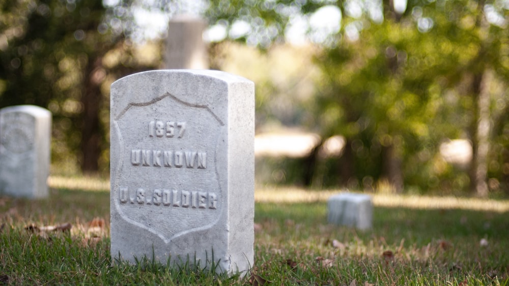 gray concrete tomb on green grass field during daytime