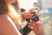 person holding pink and green flower