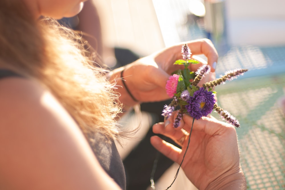 person holding pink and green flower