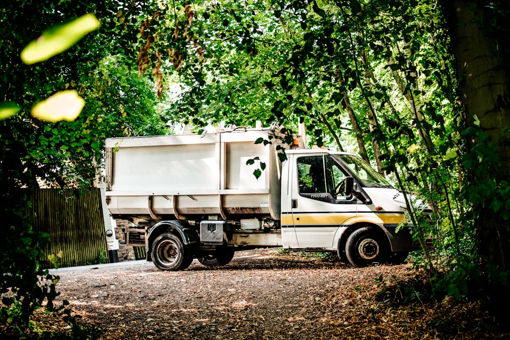 white and green truck on dirt road during daytime