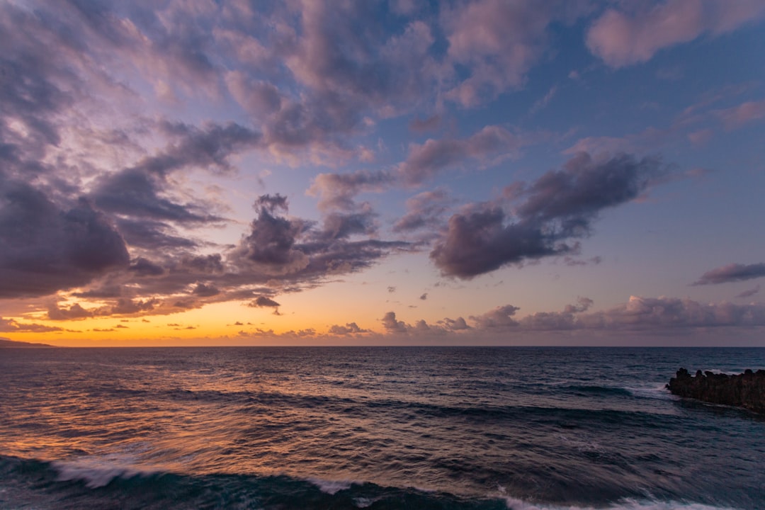 sea waves under cloudy sky during sunset