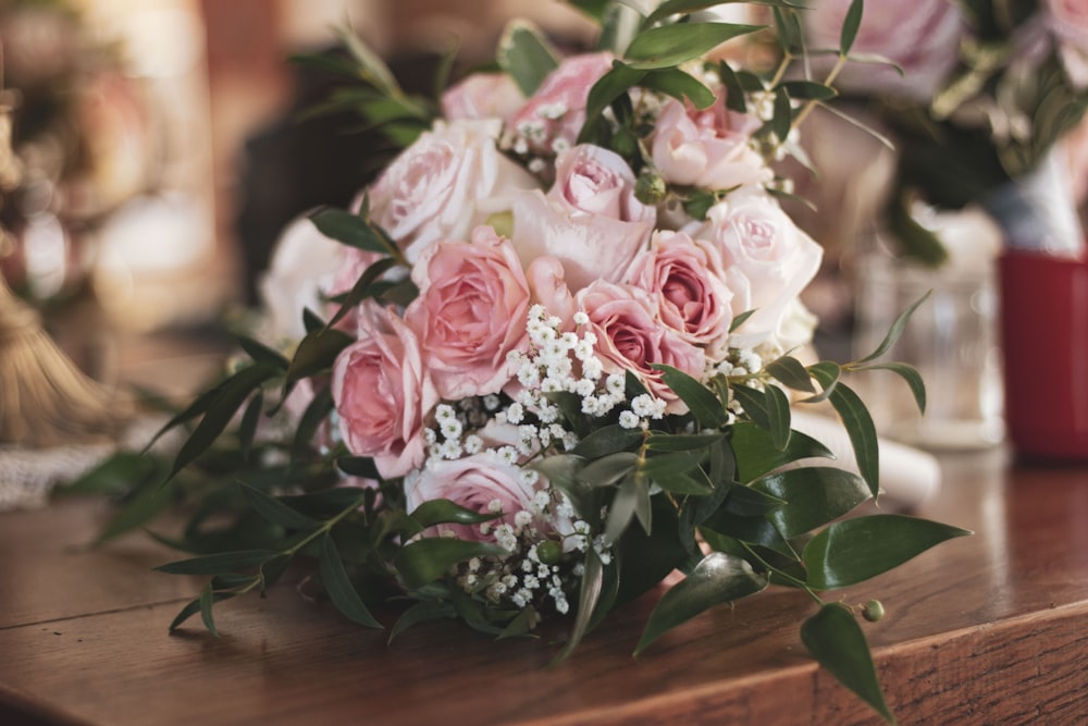 pink roses on brown wooden table