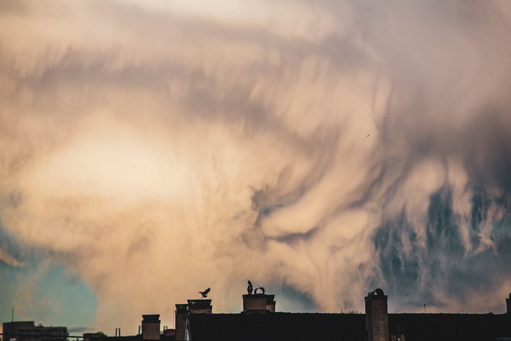 silhouette of building under cloudy sky during daytime