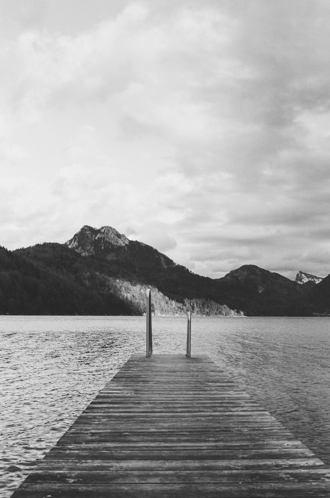 grayscale photo of wooden dock on lake