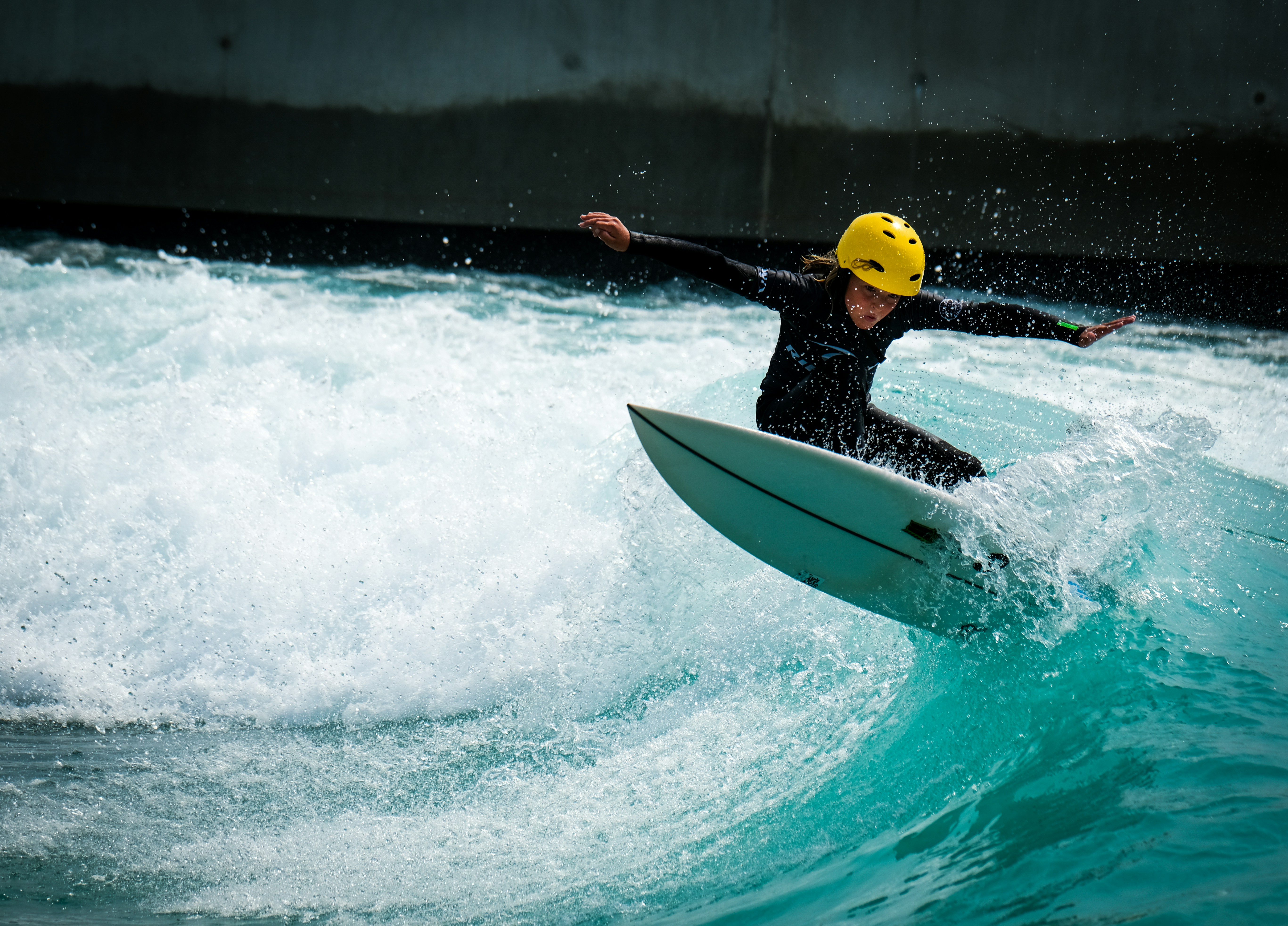 man in yellow life vest riding white surfboard during daytime, Photo of grom boy kid surfer, surfing the surf in Bristol at The Wave wavepool.