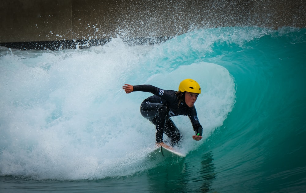 man in black wet suit wearing yellow hard hat in water