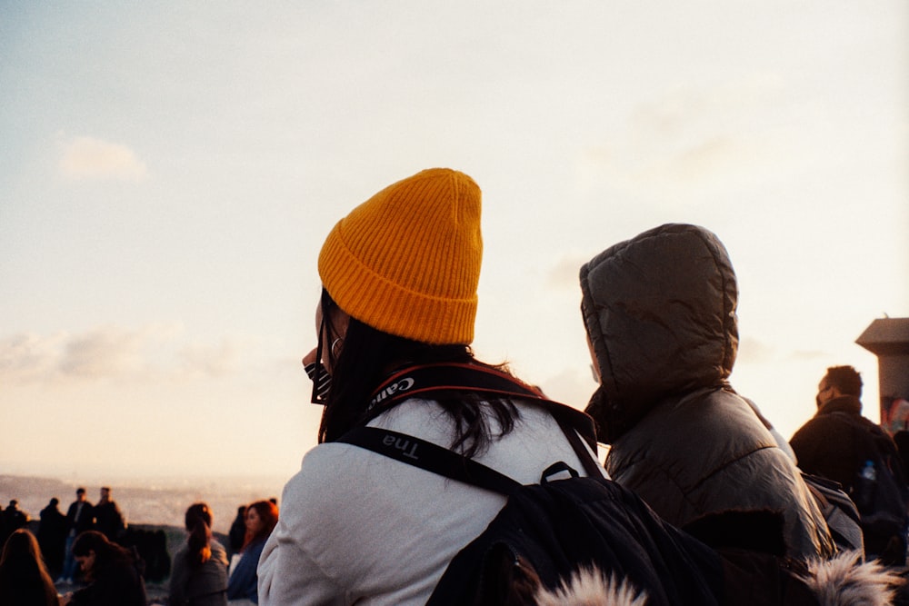 man in black jacket and orange knit cap