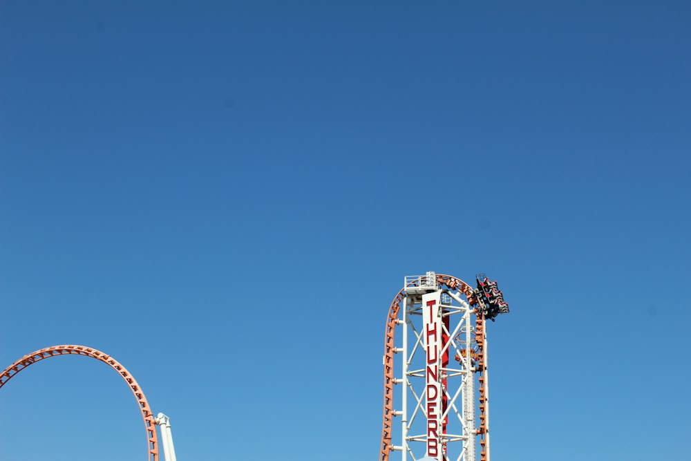 red and white ferris wheel under blue sky during daytime