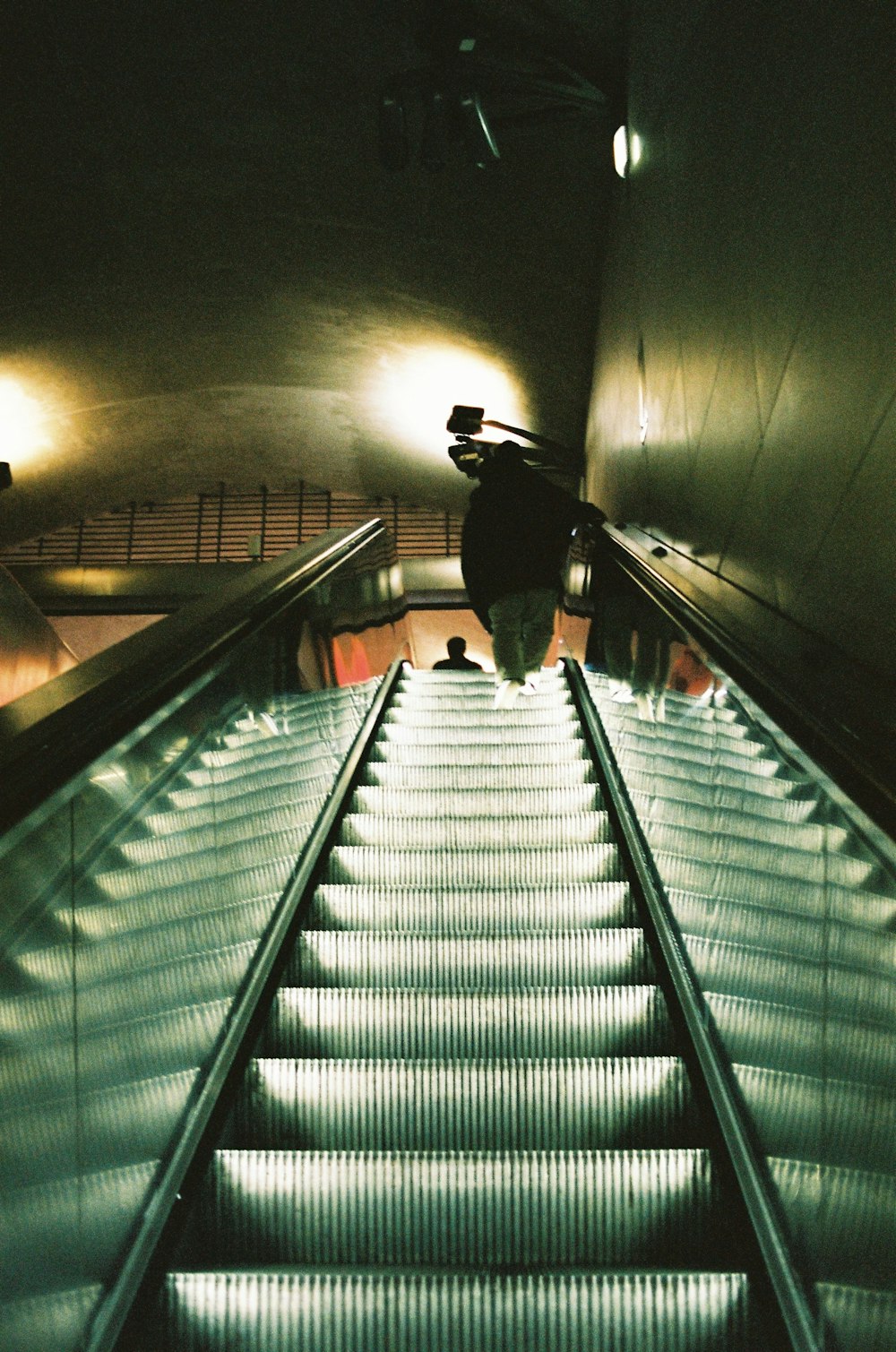 man in black jacket walking on gray staircase