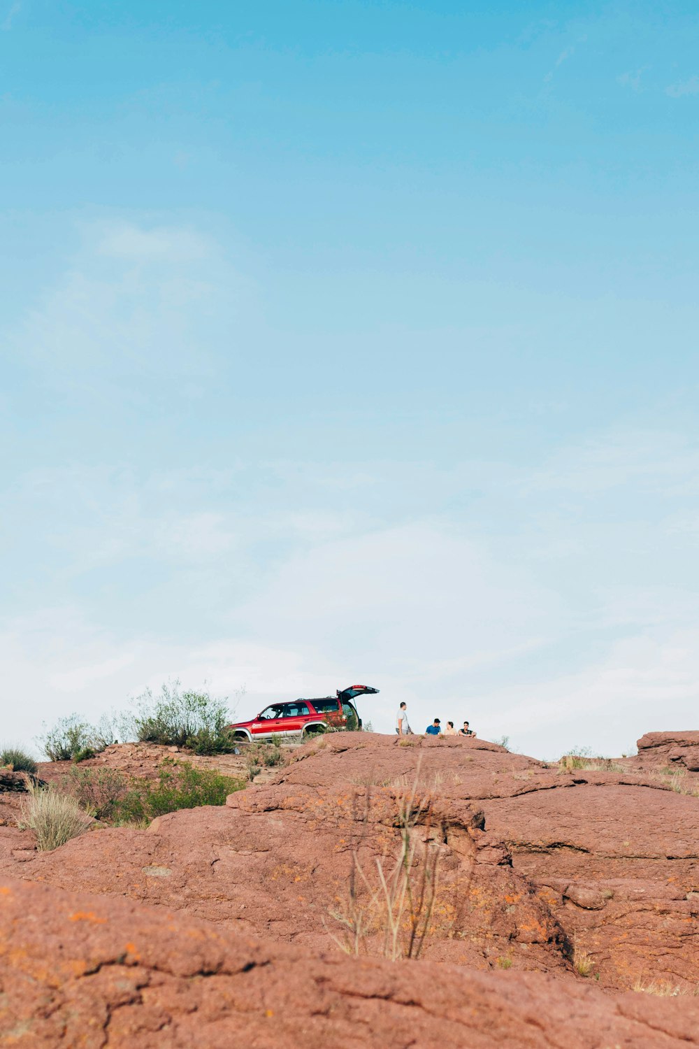 person in blue jacket and black pants standing on brown rock during daytime