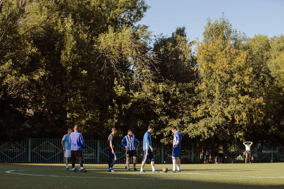 people playing basketball on green grass field during daytime