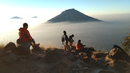 people standing on brown grass field near mountain during daytime in Temanggung Indonesia