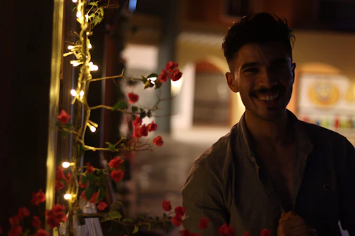 A smiling small business owner standing beside solar-powered lights inside their store.