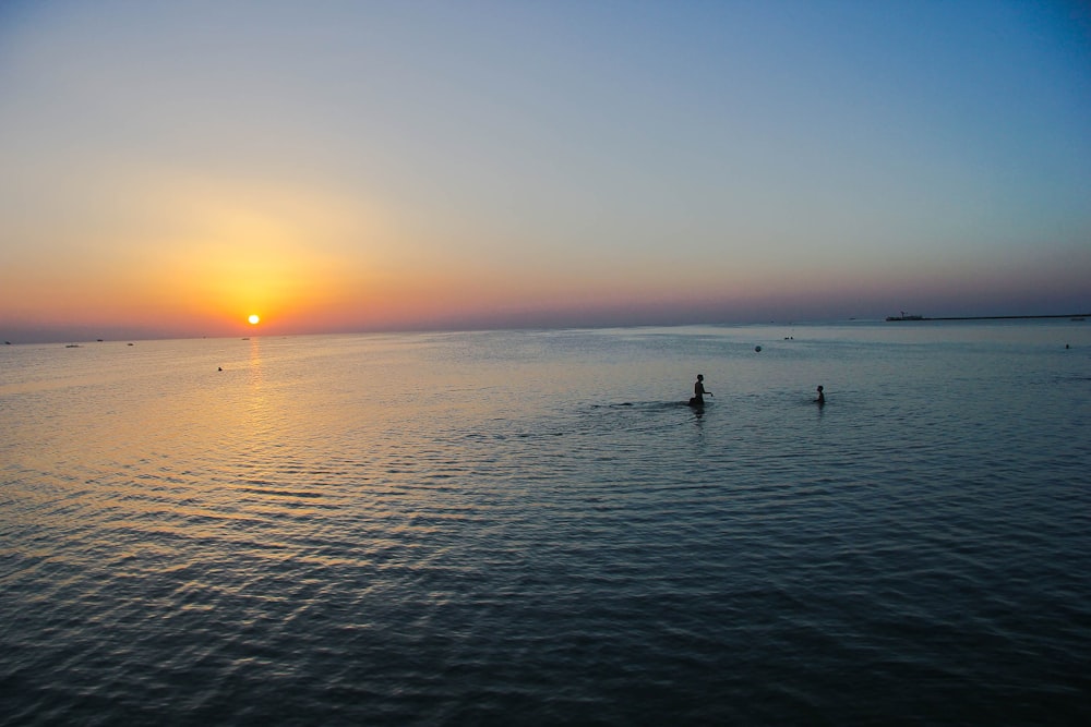 people on sea during sunset