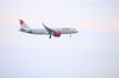 A commercial airplane in flight against a pale sky, featuring the logo and branding of Viva Aerobus on its fuselage and tail. The aircraft has red engines and markings, with visible landing gear extended.