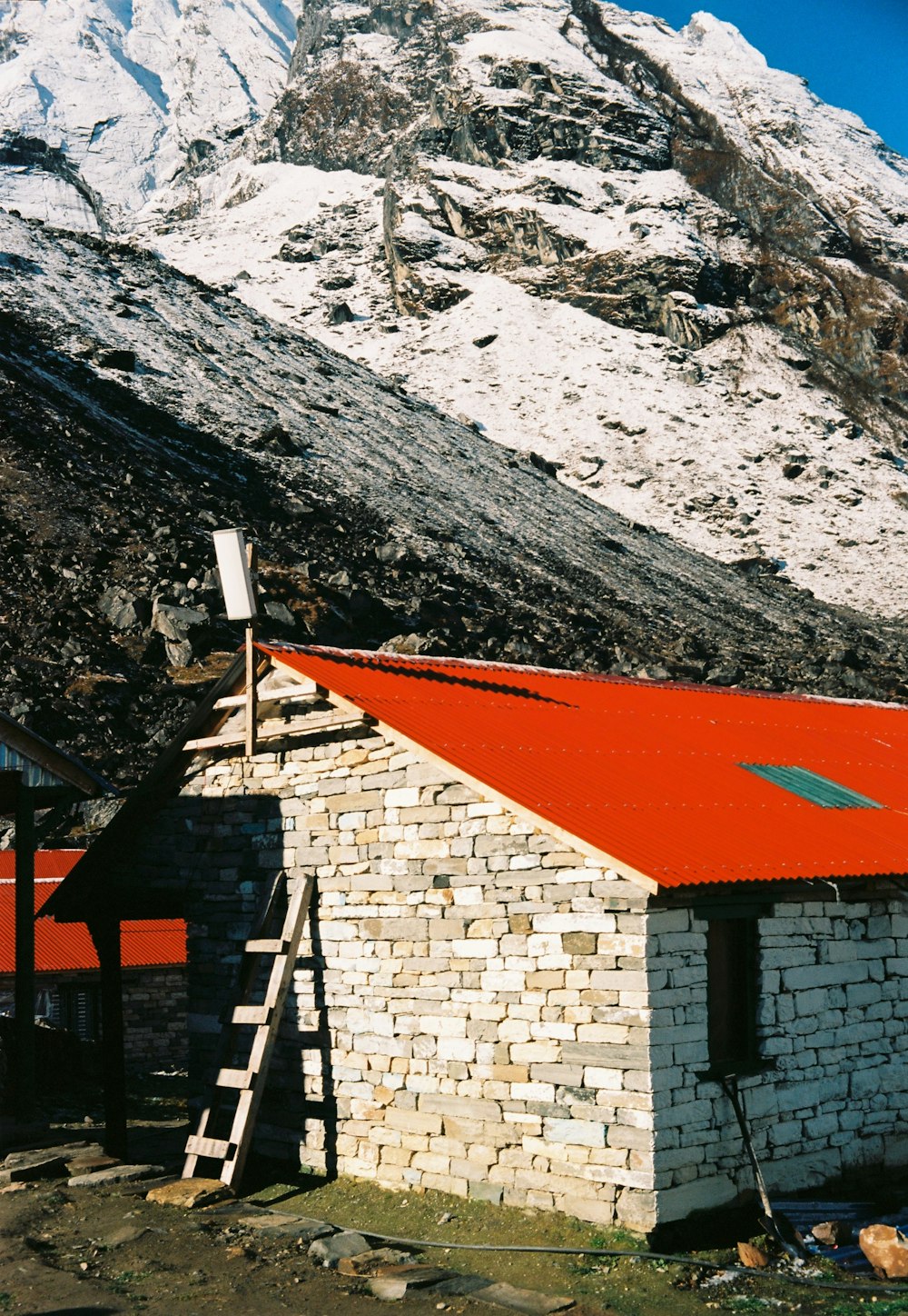 Maison en brique brune près de la montagne pendant la journée