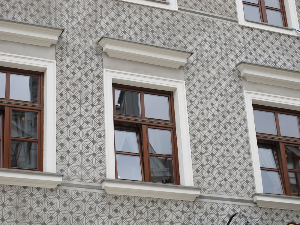 a building with three windows and a clock on the side of it