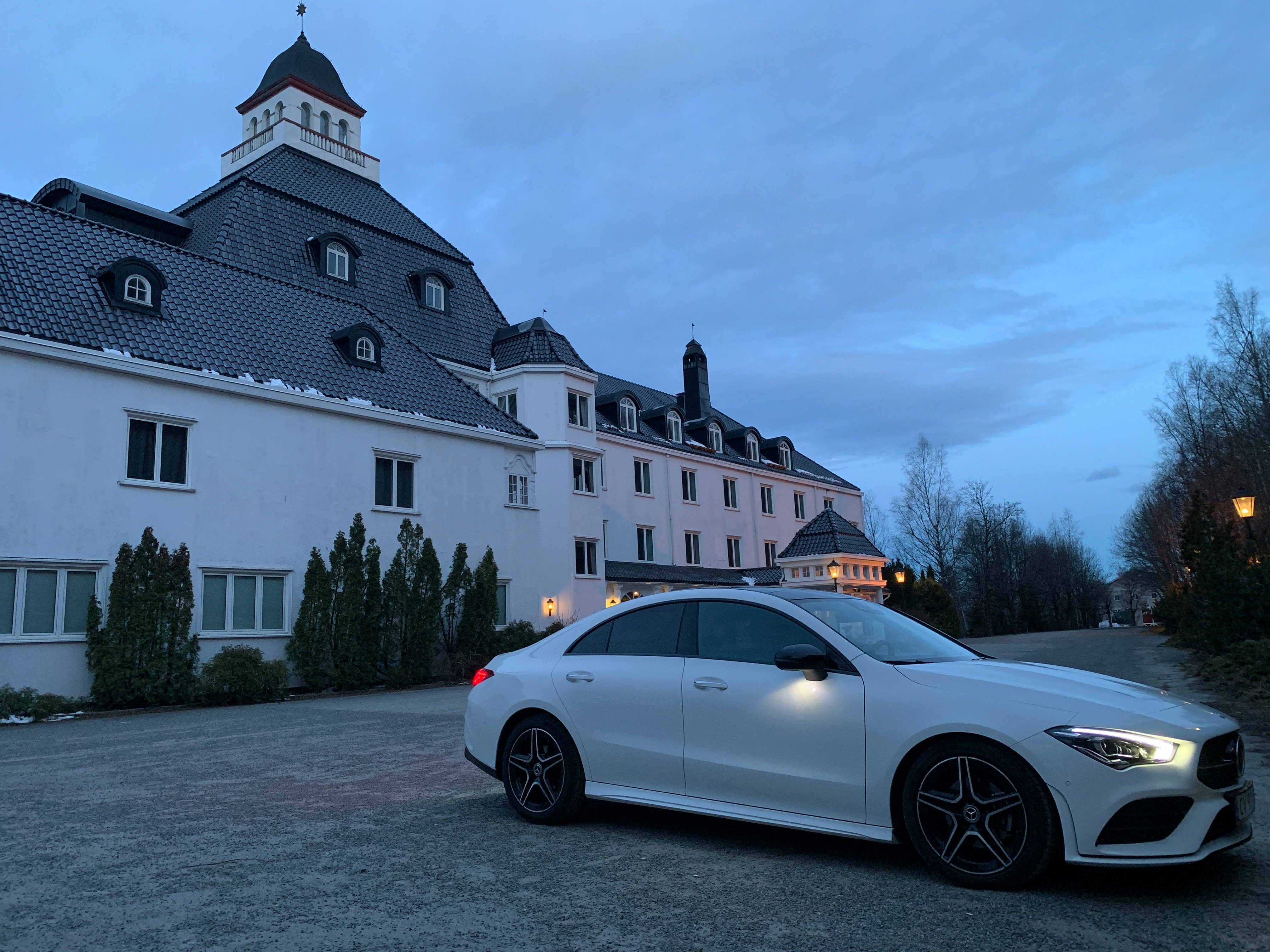 white coupe parked beside white concrete building during daytime