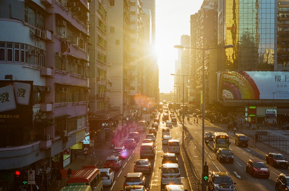 cars on road between high rise buildings during night time