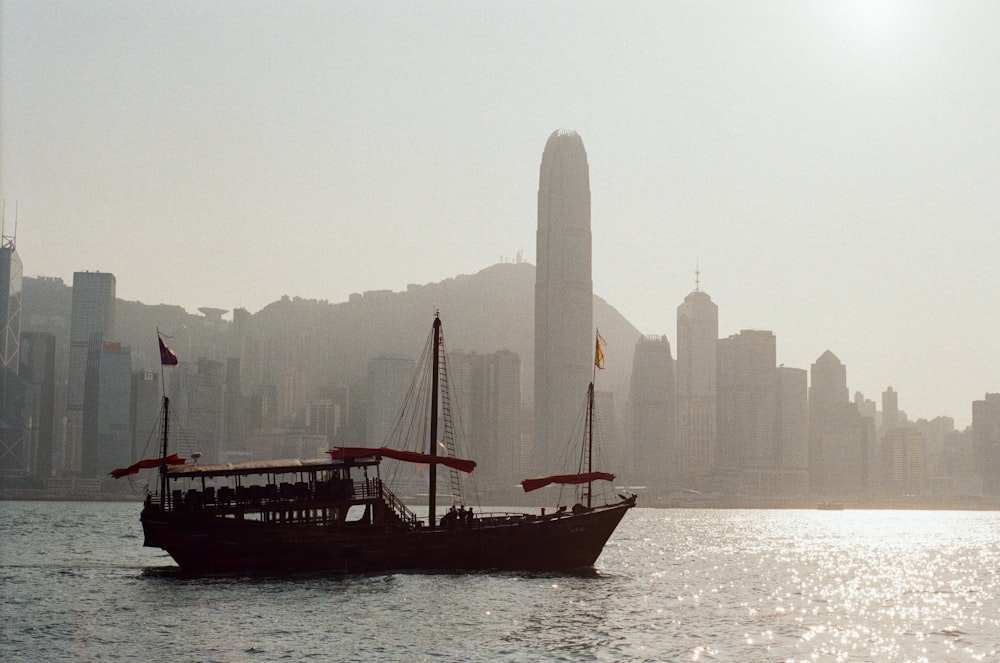 black ship on sea near city buildings during daytime