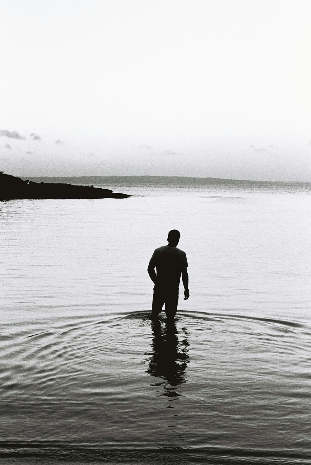 silhouette of man standing on water