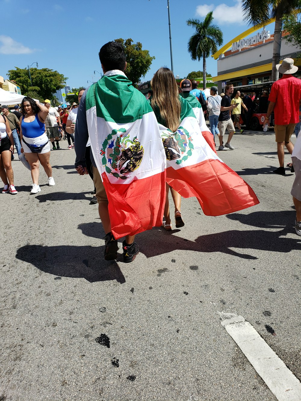 woman in green and red dress walking on gray concrete pavement during daytime