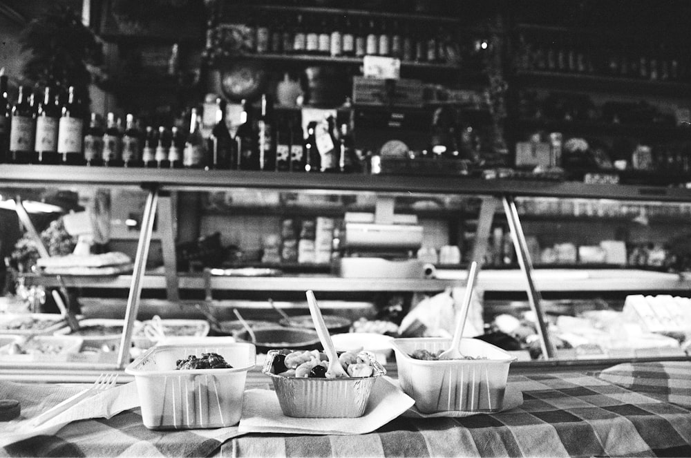 grayscale photo of plastic cups and bowls on table