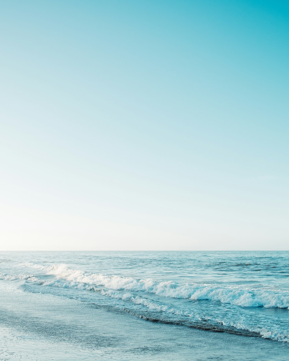 vagues de l’océan sous le ciel bleu pendant la journée