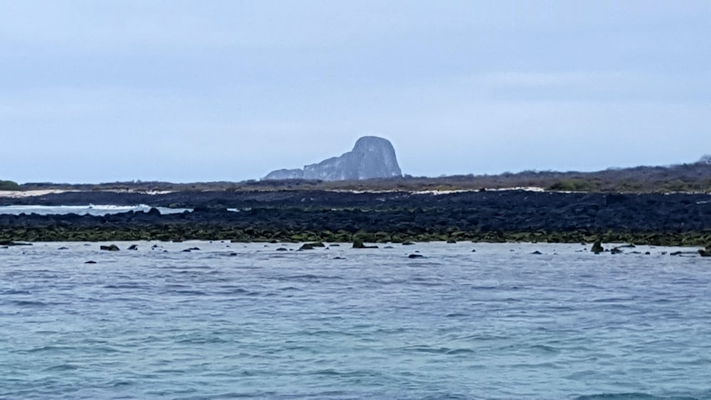 body of water near mountain during daytime