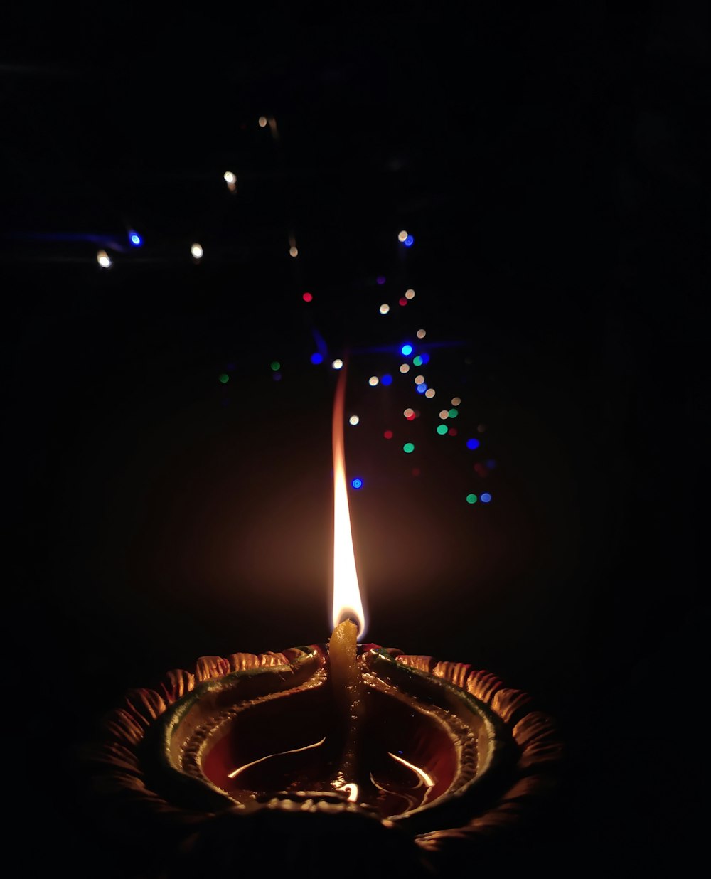 lighted candle in the dark