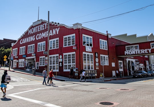 people walking near red concrete building during daytime in Monterey Canning Company United States