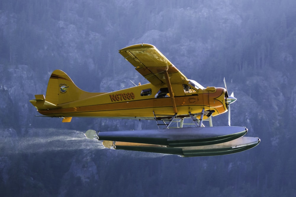 yellow and white plane flying over the sea during daytime