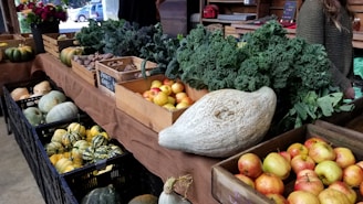 A vibrant display of fresh fruits and vegetables arranged in wooden crates at a market stall.