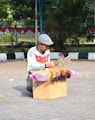 man in white and black shirt and white cap sitting on brown cardboard box