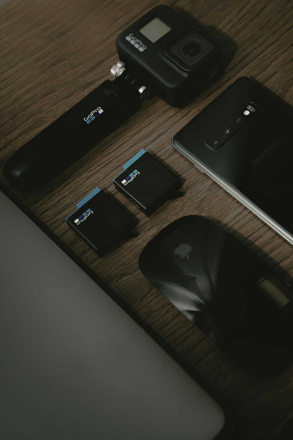 black iphone 7 plus beside black camera on brown wooden table