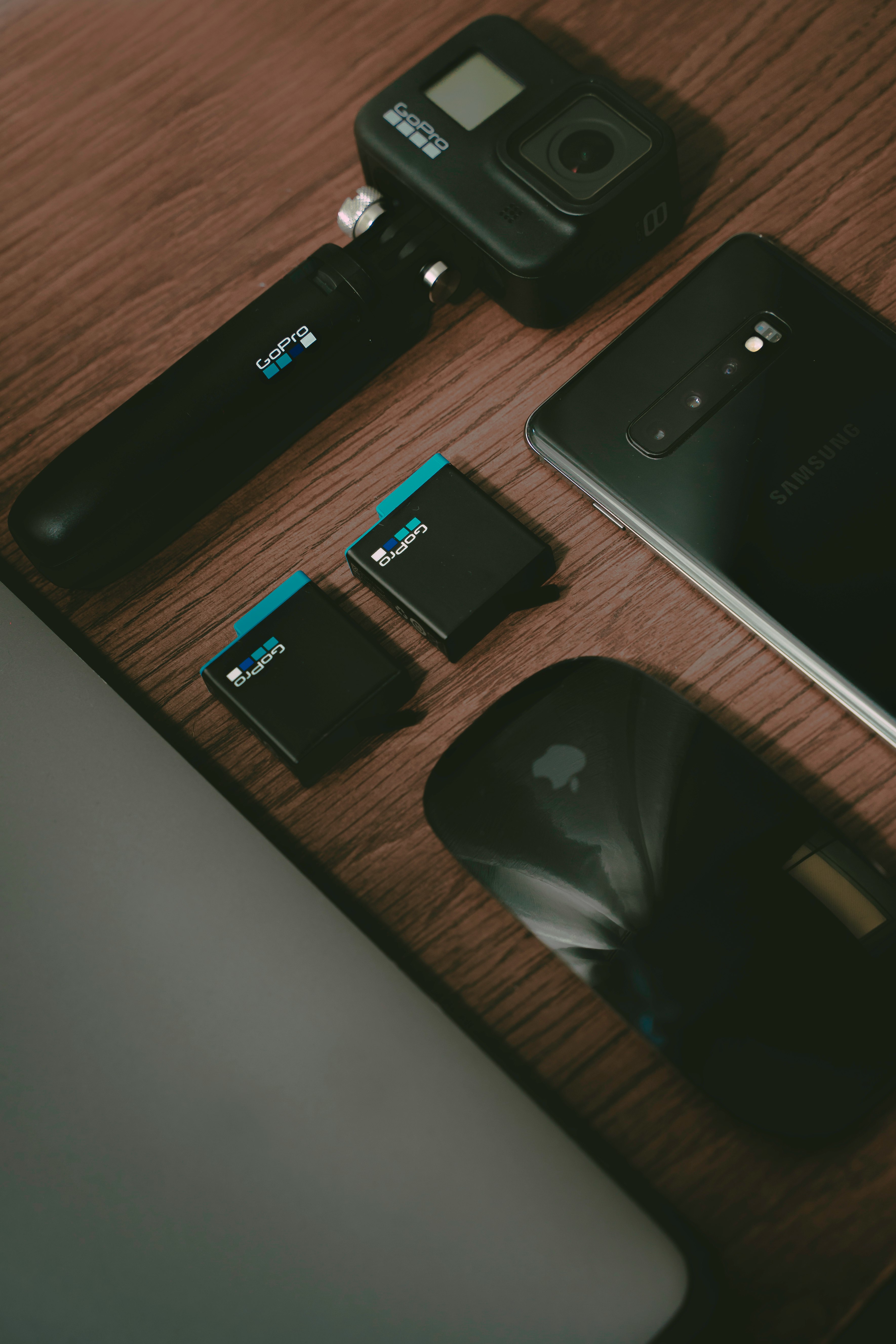 black iphone 7 plus beside black camera on brown wooden table