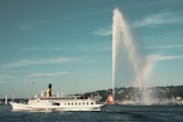 white ship on water fountain under blue sky during daytime
