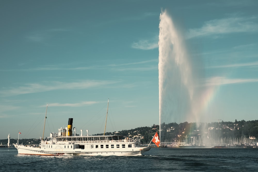 white ship on water fountain under blue sky during daytime