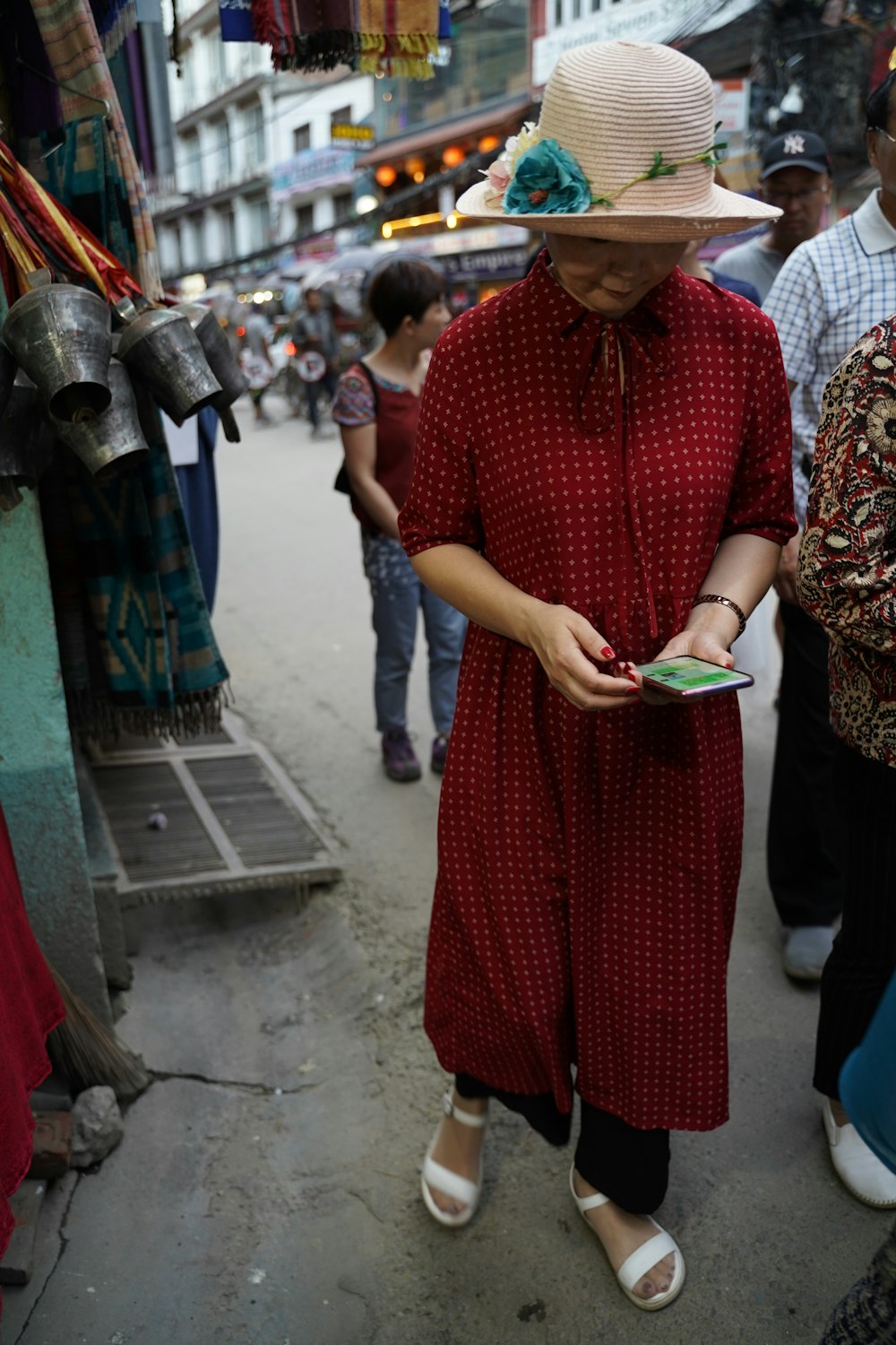 woman in red and white dress holding smartphone